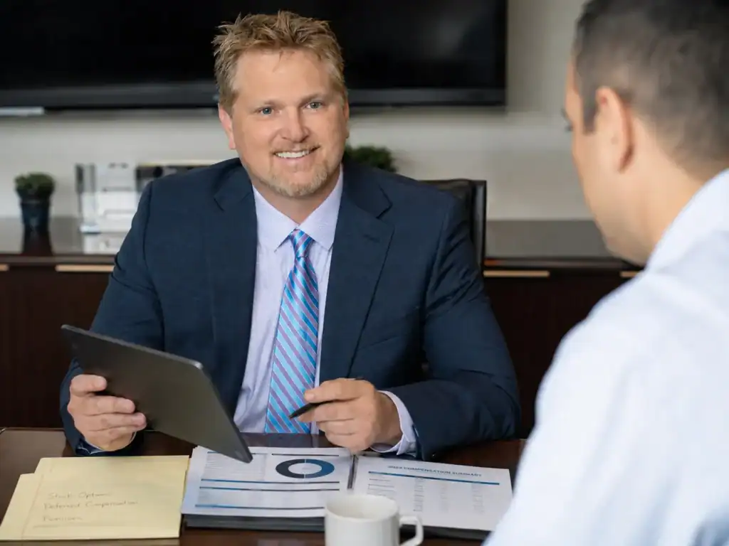 Raleigh divorce lawyer reviewing stock options, bonuses, deferred compensation, and financial records with a technology professional